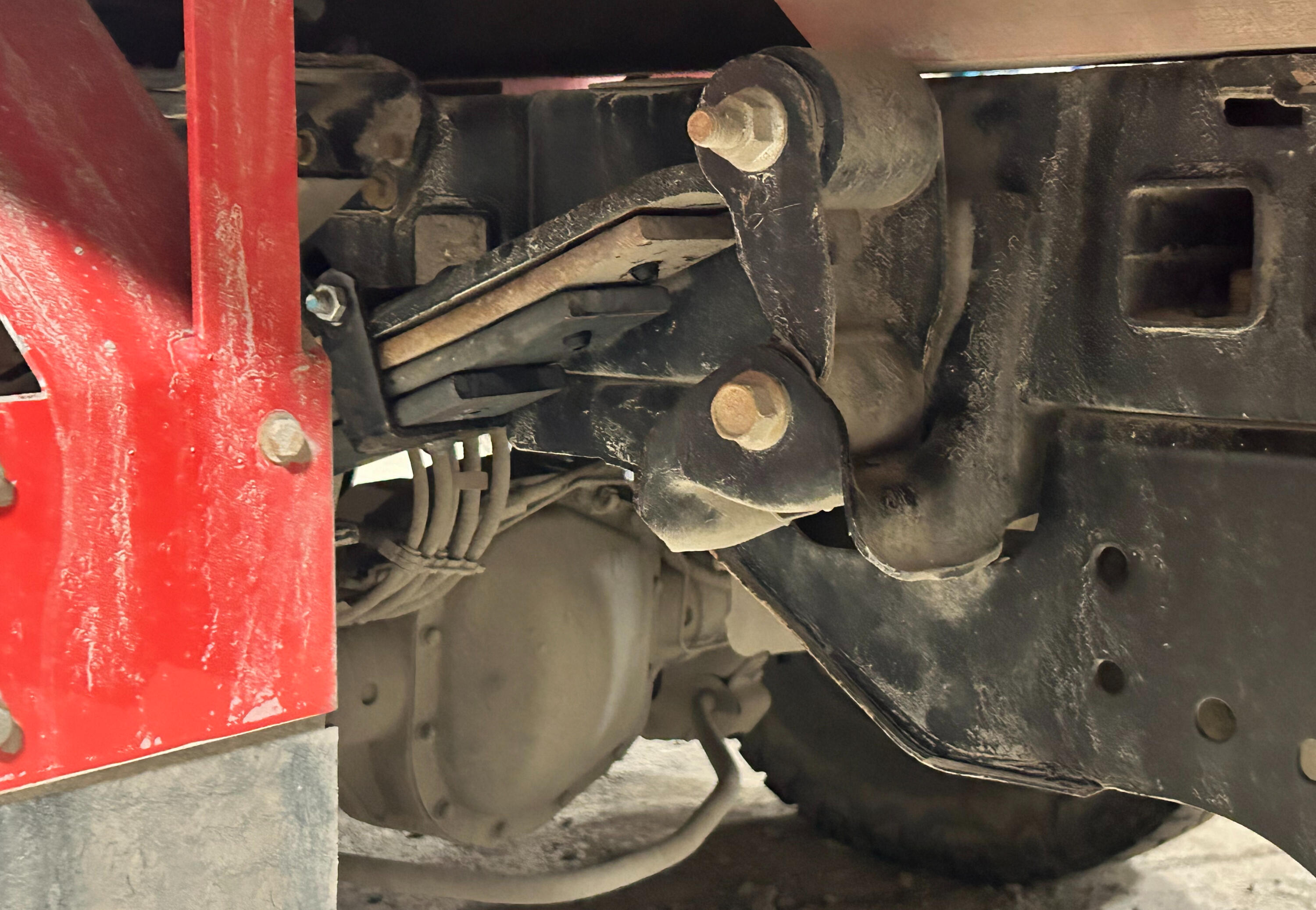 Heavy-duty truck suspension hardware including shackles, bushings, spring hangers, mounting brackets, pins, and suspension components installed and serviced at Standard Auto Spring Works in Winnipeg.