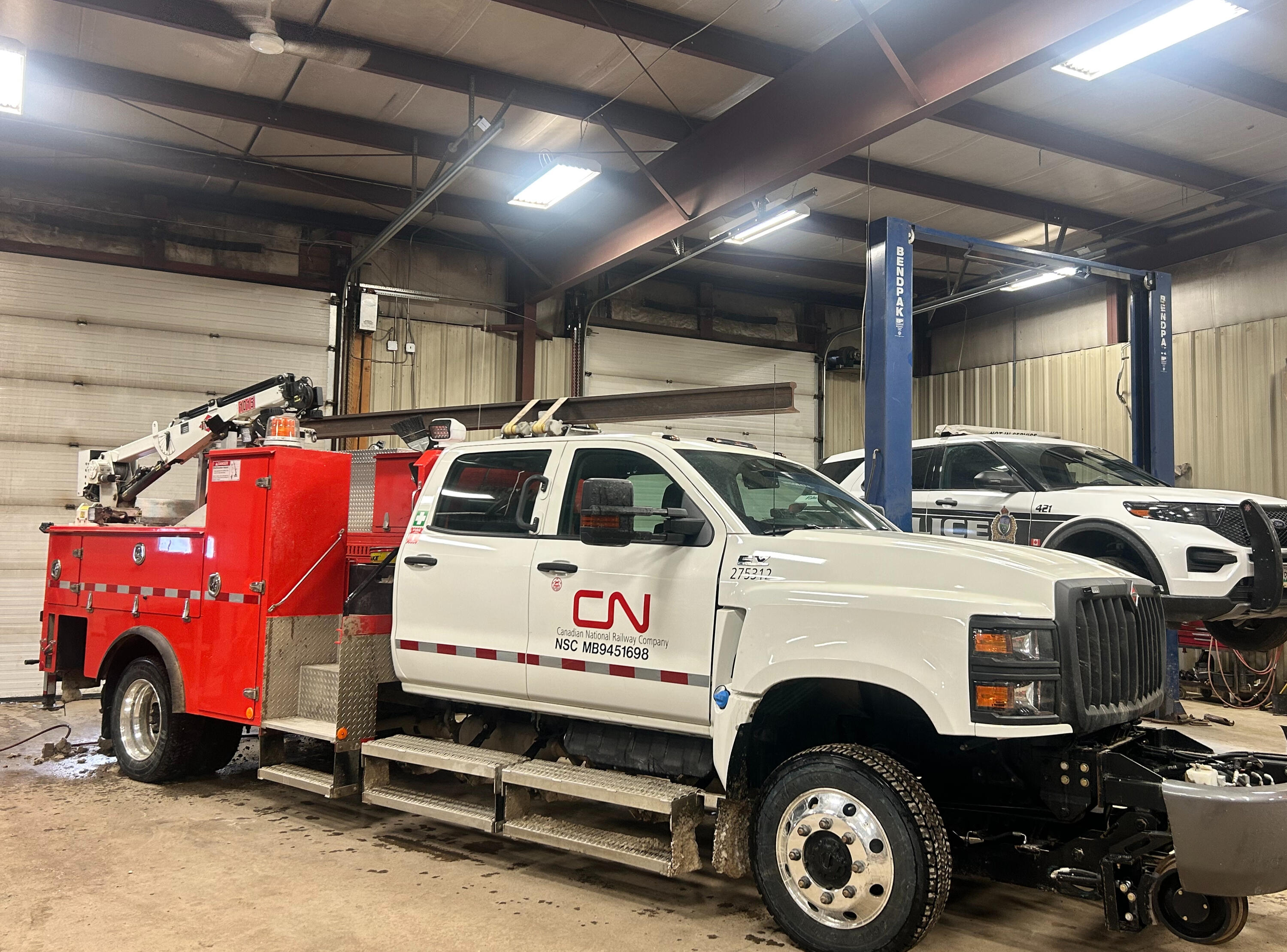 Heavy-duty service truck receiving suspension upgrades at Standard Auto Spring Works in Winnipeg. HD leaf springs, add-a-leaf kits, lift kits, load support systems, and fleet suspension enhancements for commercial work trucks.