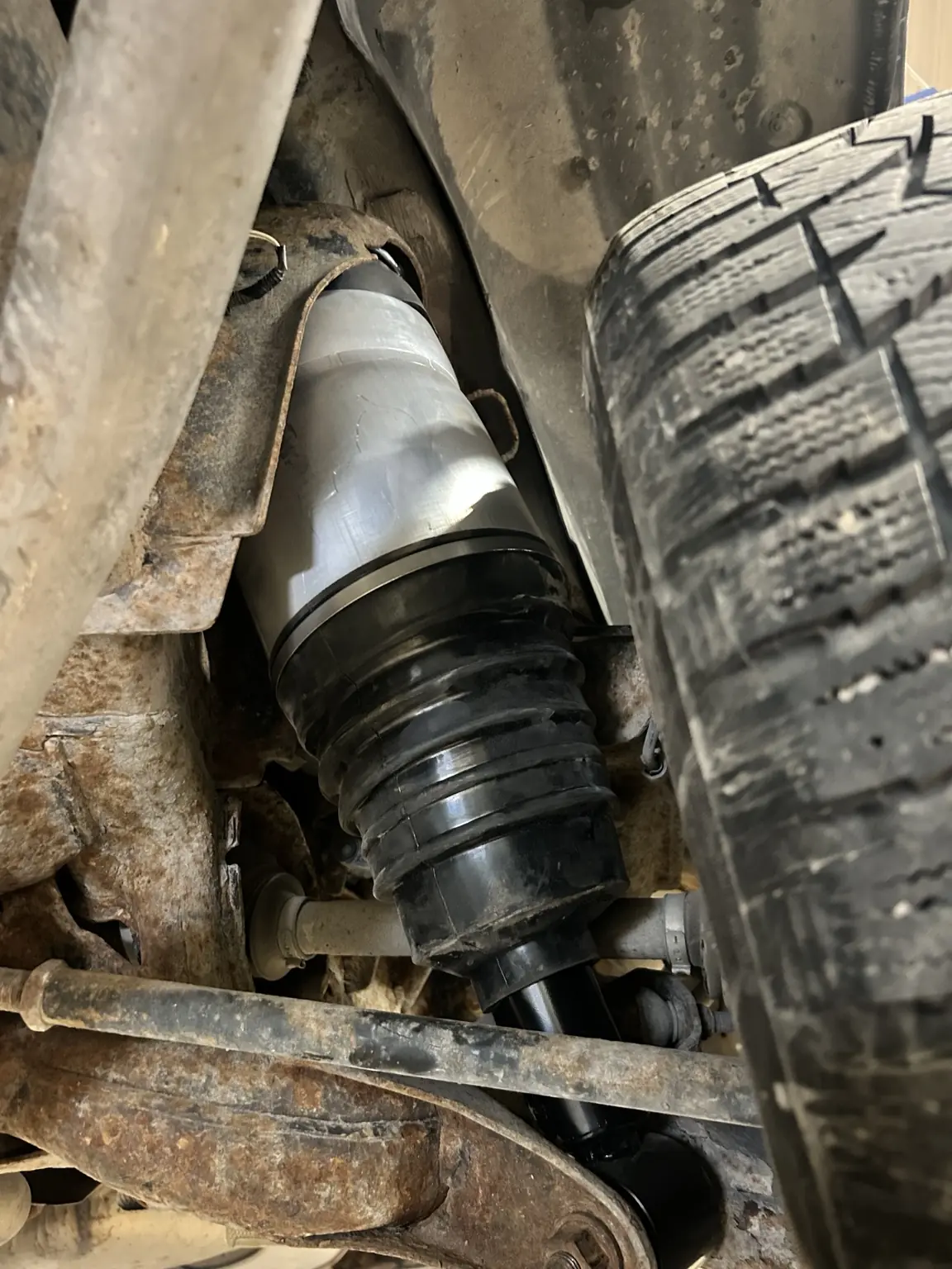 Air spring and shock assembly installed in a vehicle wheel well