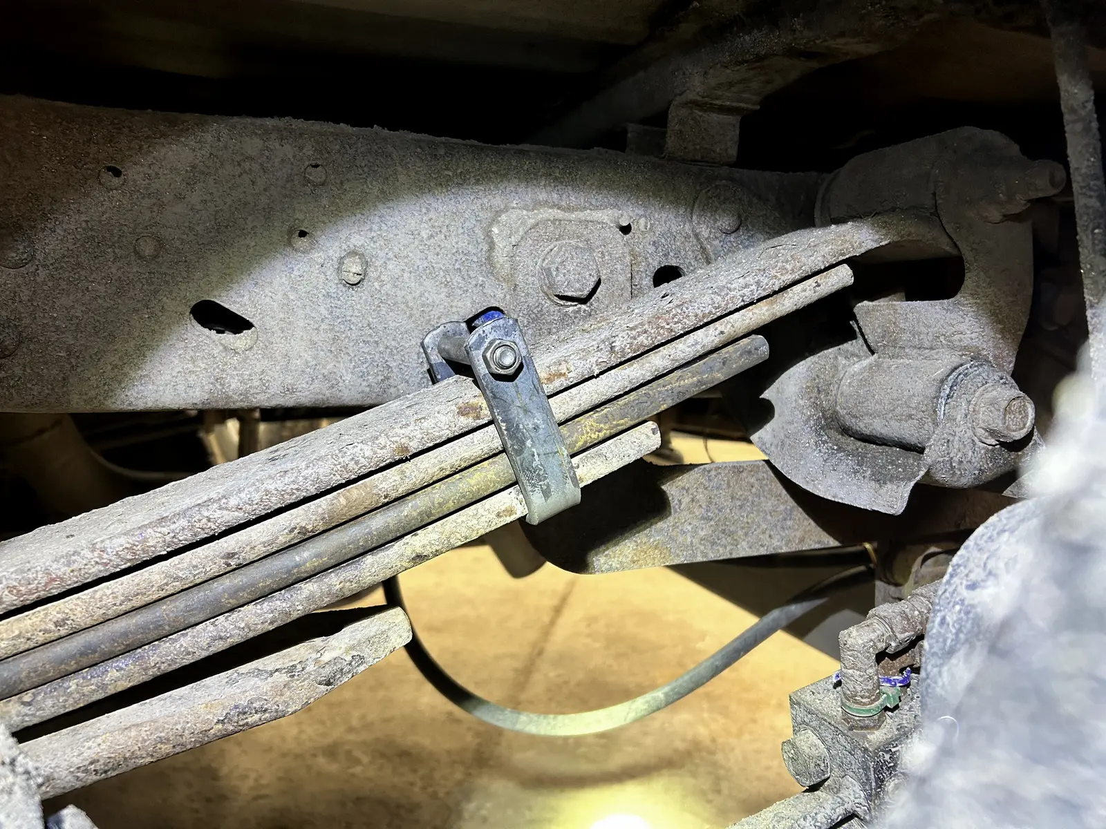Close view of a visibly broken leaf in a multi leaf spring pack