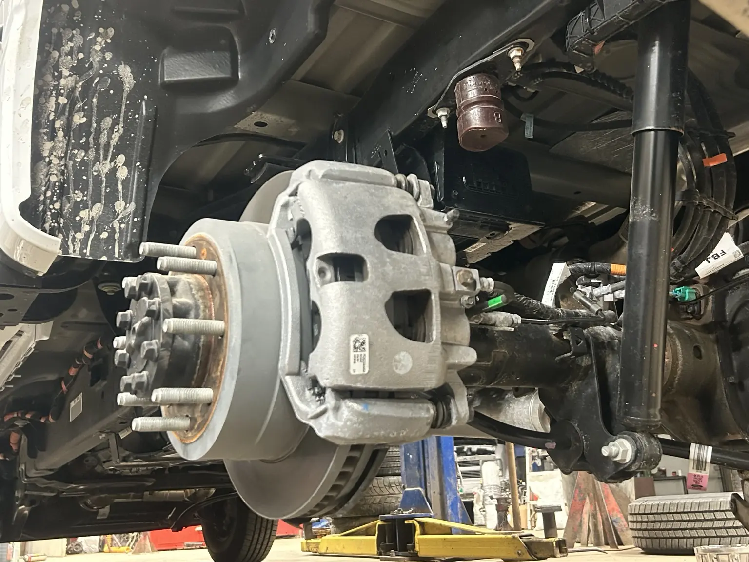 Brake rotor, caliper, shock and suspension components exposed during mechanical repair