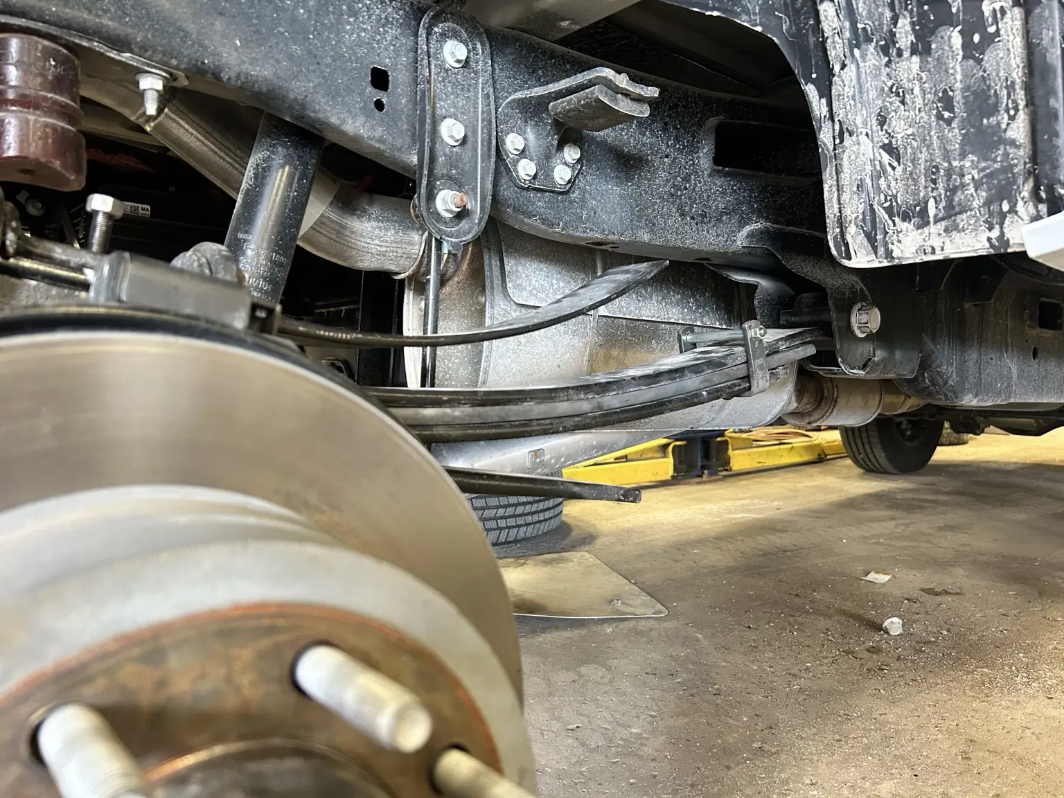 Leaf spring, shackle and shock assembly exposed for inspection