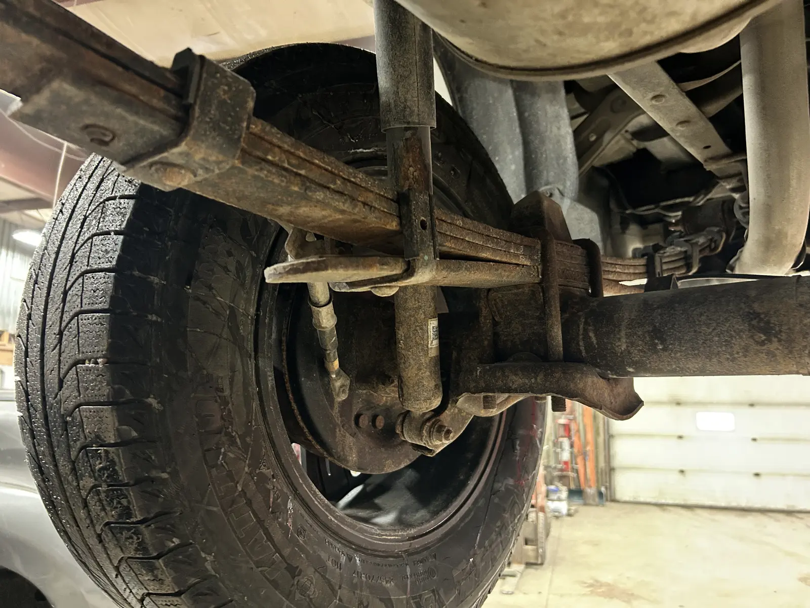 Rear leaf spring pack, U-bolts and shock exposed for inspection